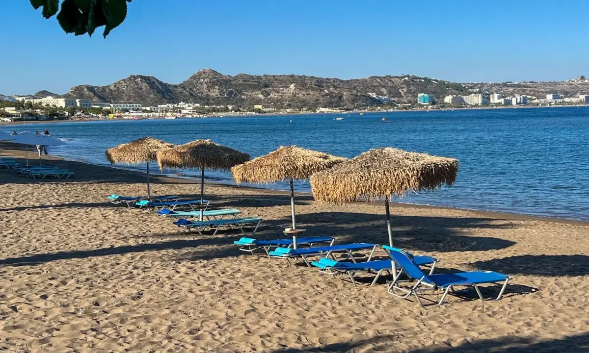 Słoneczna plaża z leżakami i parasolami, idealne miejsce na pracę za granicą na wakacje.
