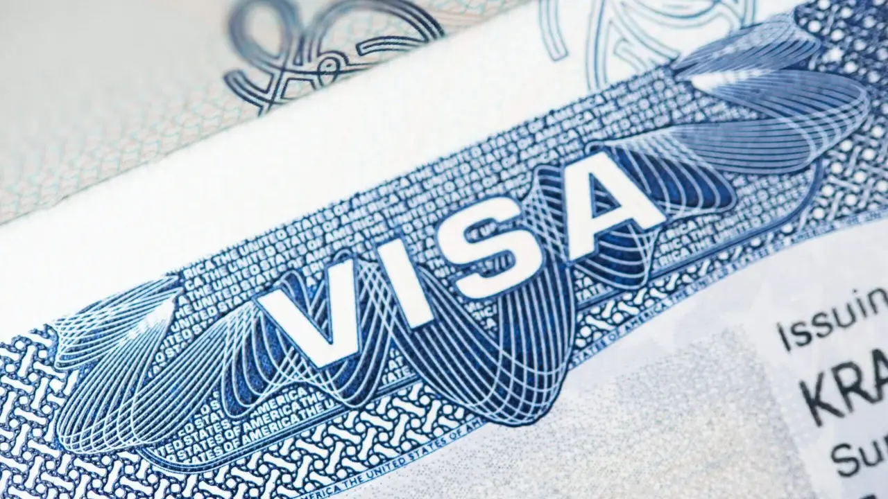 Zbliżenie na dokument z napisem "VISA" i elementami graficznymi. To może być wiza pracownicza USA, klucz do kariery za oceanem.