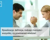 Mężczyzna i kobieta mierzą się w siłowaniu na ręce, symbolizując rywalizację.