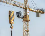 Kabina operatora dźwigu Liebherr, z której widać hak i łańcuchy, gotowa do pracy na budowie.