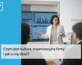 Kobieta w białej marynarce prezentuje wykresy, omawiając kluczowe aspekty kultury organizacyjnej firmy.