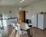 Wspólna kuchnia z jadalnią, idealna na **pracę w Belgii bez języka z zakwaterowaniem**. Dwa lodówki, blat roboczy, stół z krzesłami.