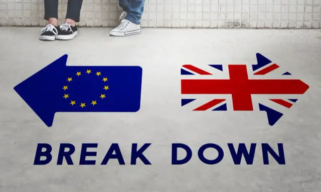 Strzałki z flagami UE i UK oraz napis "BREAK DOWN". Może to symbolizować trudności w uzyskaniu wizy pracowniczej UK po Brexicie.