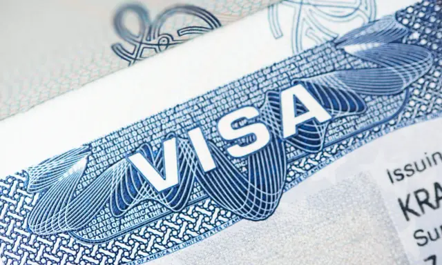 Zbliżenie na dokument z napisem "VISA" i elementami graficznymi. To może być wiza pracownicza USA, klucz do kariery za oceanem.