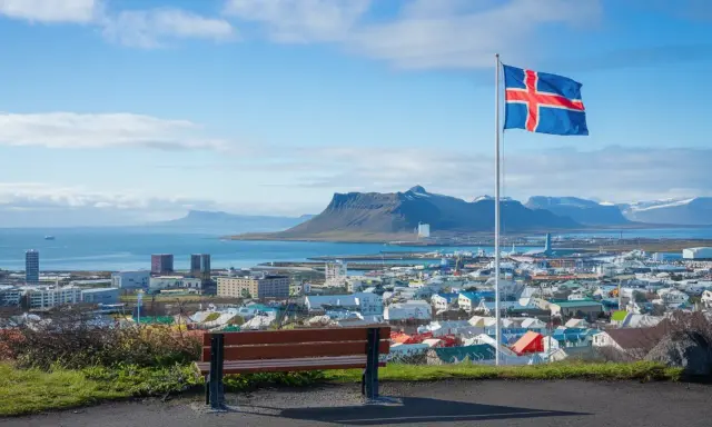 Widok na Reykjavík z flagą Islandii. Marzenie o pracy w Islandii staje się realne, patrząc na to miasto.