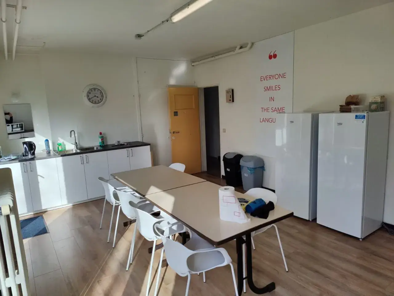 Wspólna kuchnia z jadalnią, idealna na **pracę w Belgii bez języka z zakwaterowaniem**. Dwa lodówki, blat roboczy, stół z krzesłami.