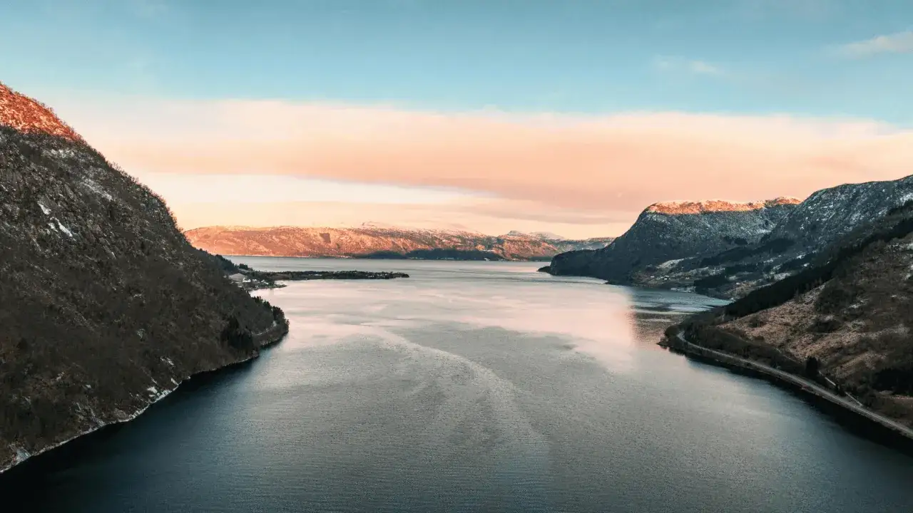 Widok na fiord w Norwegii o zachodzie słońca. Marzysz o adecco praca w norwegii bez języka? To miejsce może być Twoim nowym domem.