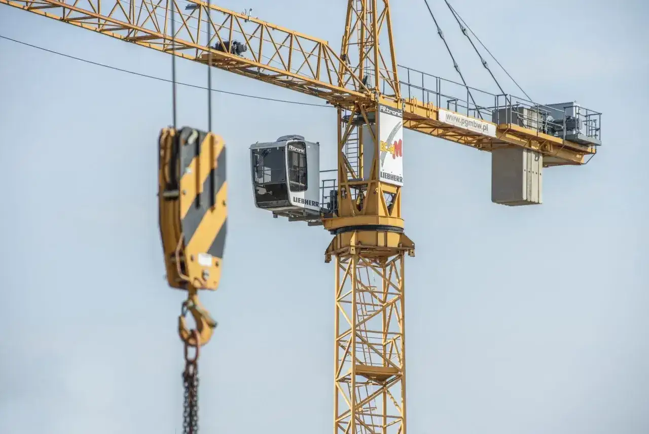 Kabina operatora dźwigu Liebherr, z której widać hak i łańcuchy.